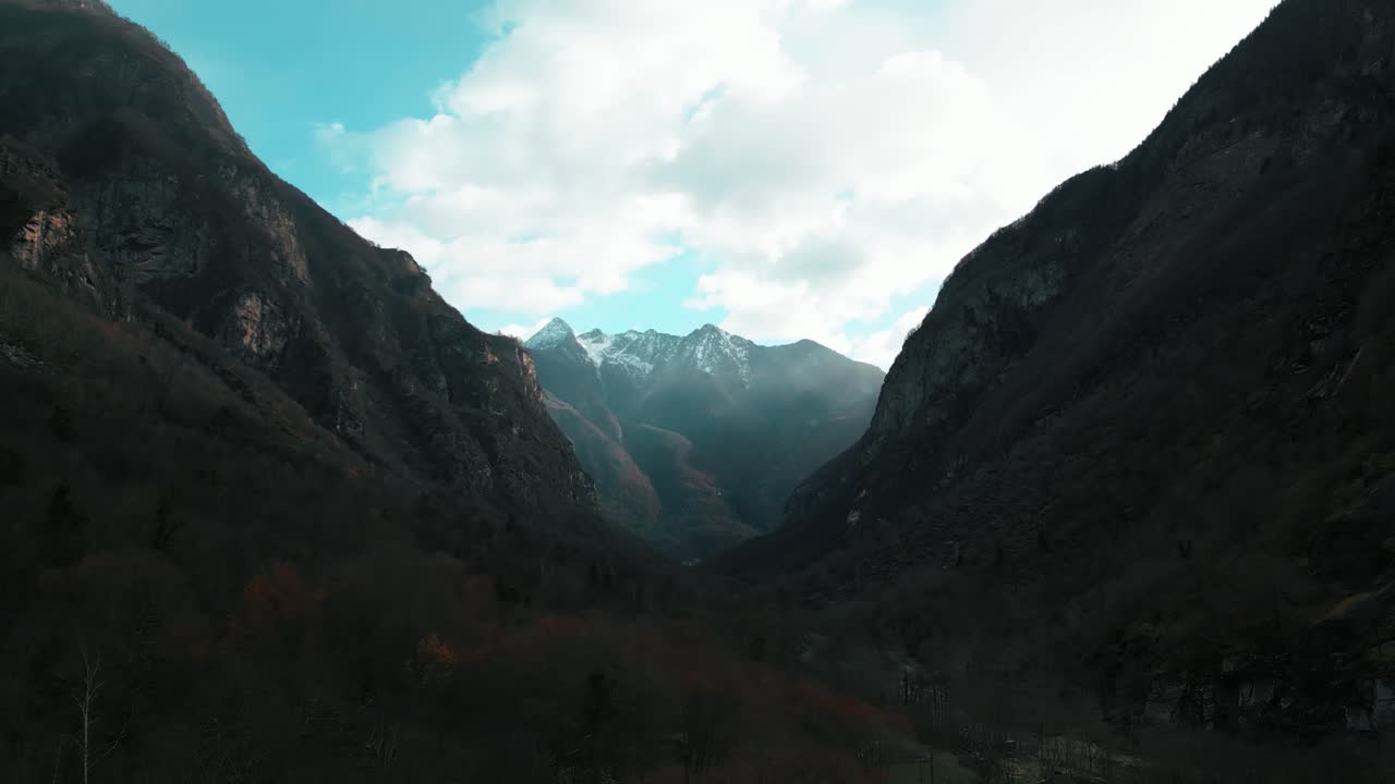 Rekaman drone miring yang perlahan menampakkan desa batu di Cavergno di balik pepohonan di lembah Maggia, terletak di distrik Vallemaggia di Swiss
