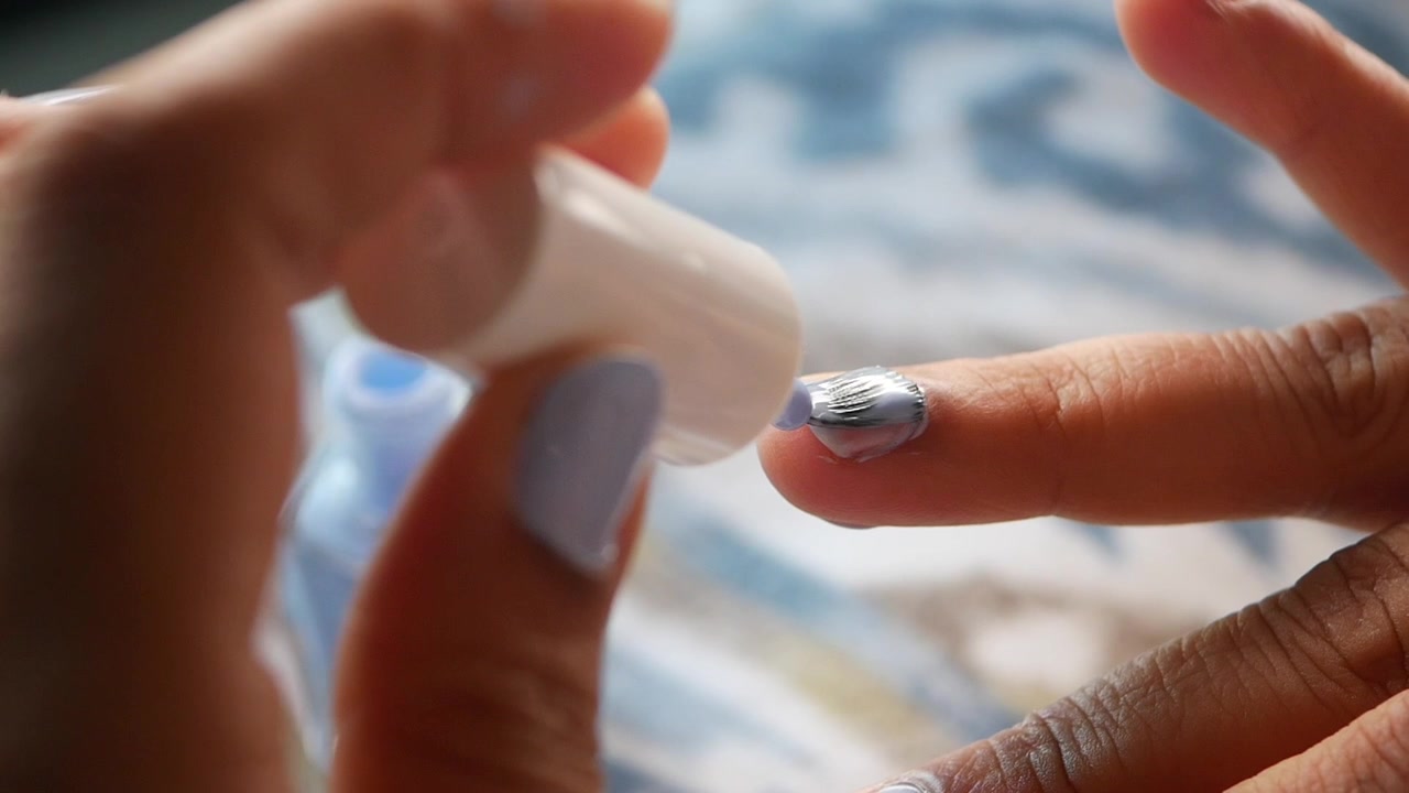Close-up of a Person Applying Light Purple Nail Polish