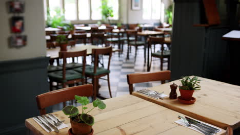 Pull-Focus-Shot-Of-Empty-Restaurant-Interior-With-Table-Settings