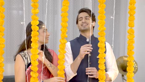 una linda pareja india decorando su casa para diwali