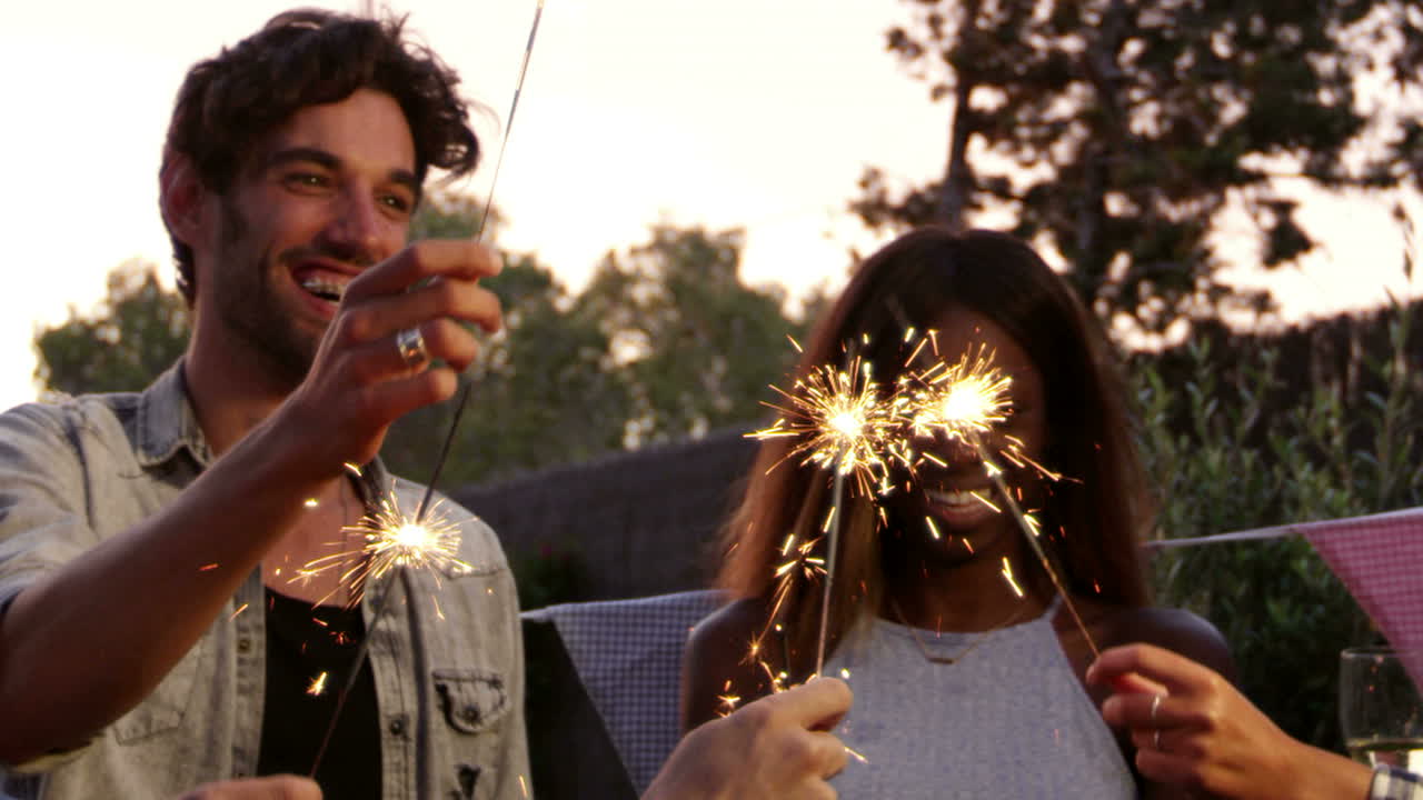 Group Of Friends With Sparklers Enjoying Outdoor Party