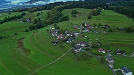 picturesque village on green field hillside in alpine countryside