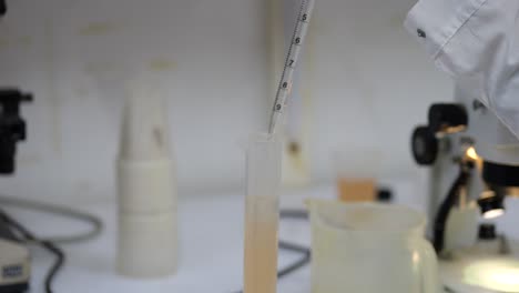 científico preparando una muestra de agua con una pipeta
