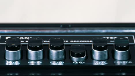 pushing play button on a vintage tape recorder