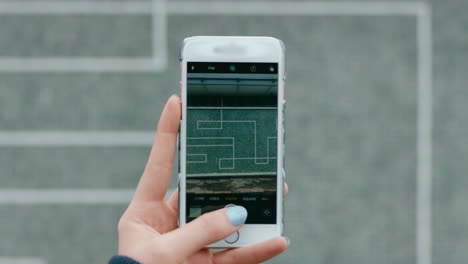 mano de cerca usando un teléfono inteligente tomando una foto de arte de mosaico en la ciudad urbana