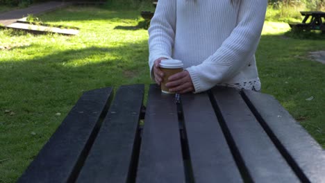 Mujer-En-El-área-De-Picnic-Disfrutando-De-Un-Café-Para-Llevar