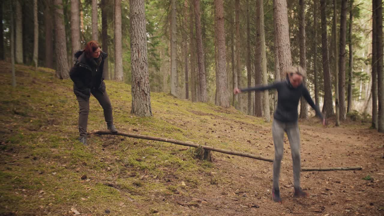 Mother and daughter scrap tree for campfire. Family leisure and outdoor activity time in the forest.