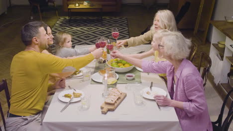 top view of a family toasting during a dinner sitting at a table and enjoying a great time 1