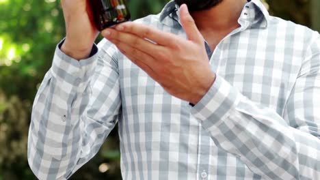 hombre sonriente examinando una botella de vino