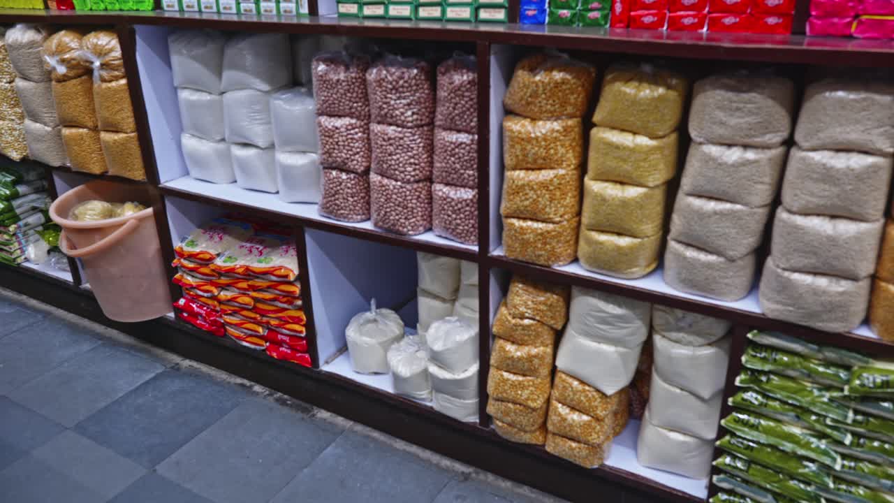 peanuts, sugar, split pigeon peas and other pulses packed in cover arrange sequential in wooden rack at kirana store or supermarket in hyderabad, telangana, india. internal shot, stable shot, 4k.