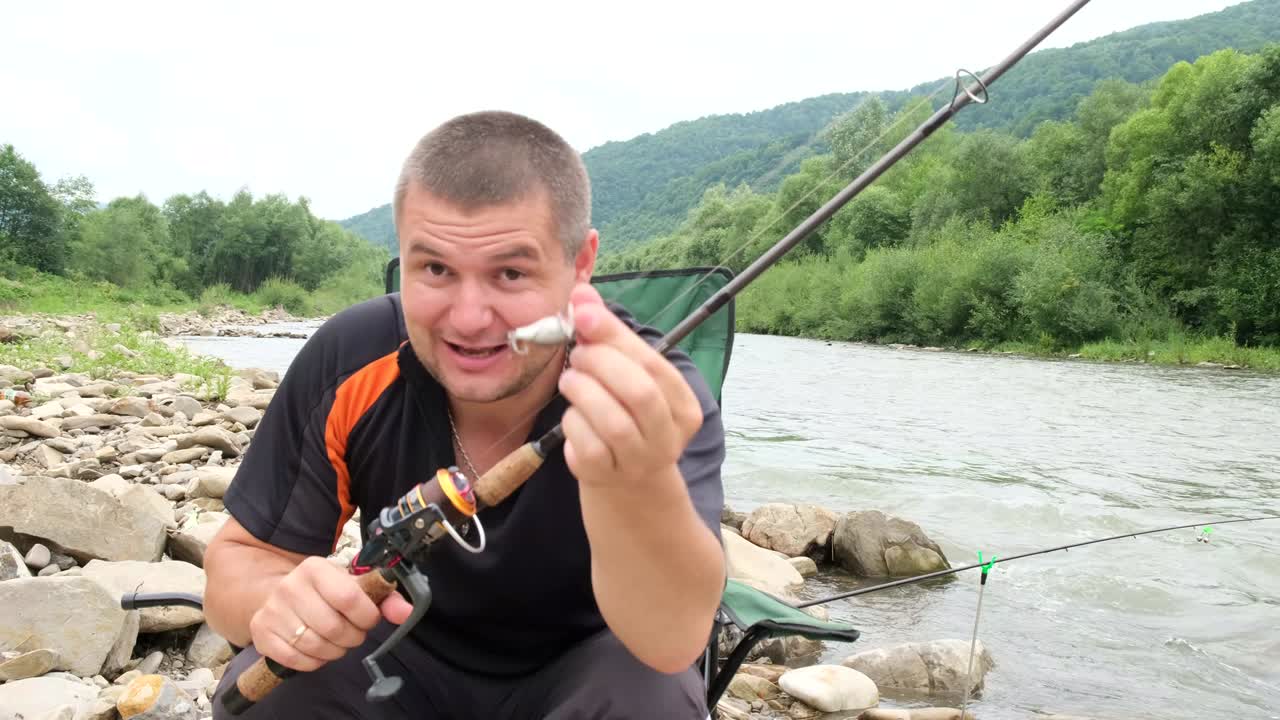 рыбак ведет блог и рассказывает камере о рыболовных приманках.