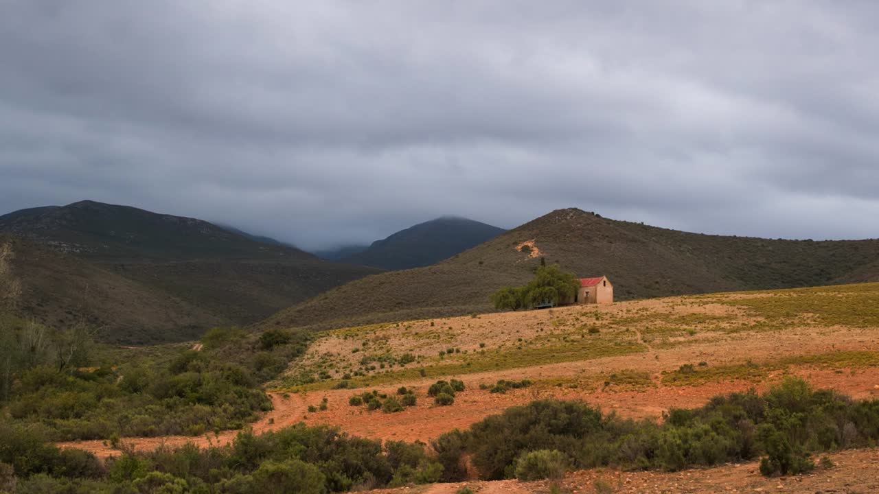 Timelapse: Nuvole dense e coperte passano sopra un paesaggio agricolo collinare