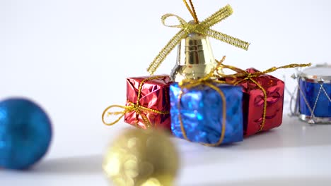 close up view and panning studio shot of christmas decorations on white background : golden ribbons, bell, snare drum and shining ball