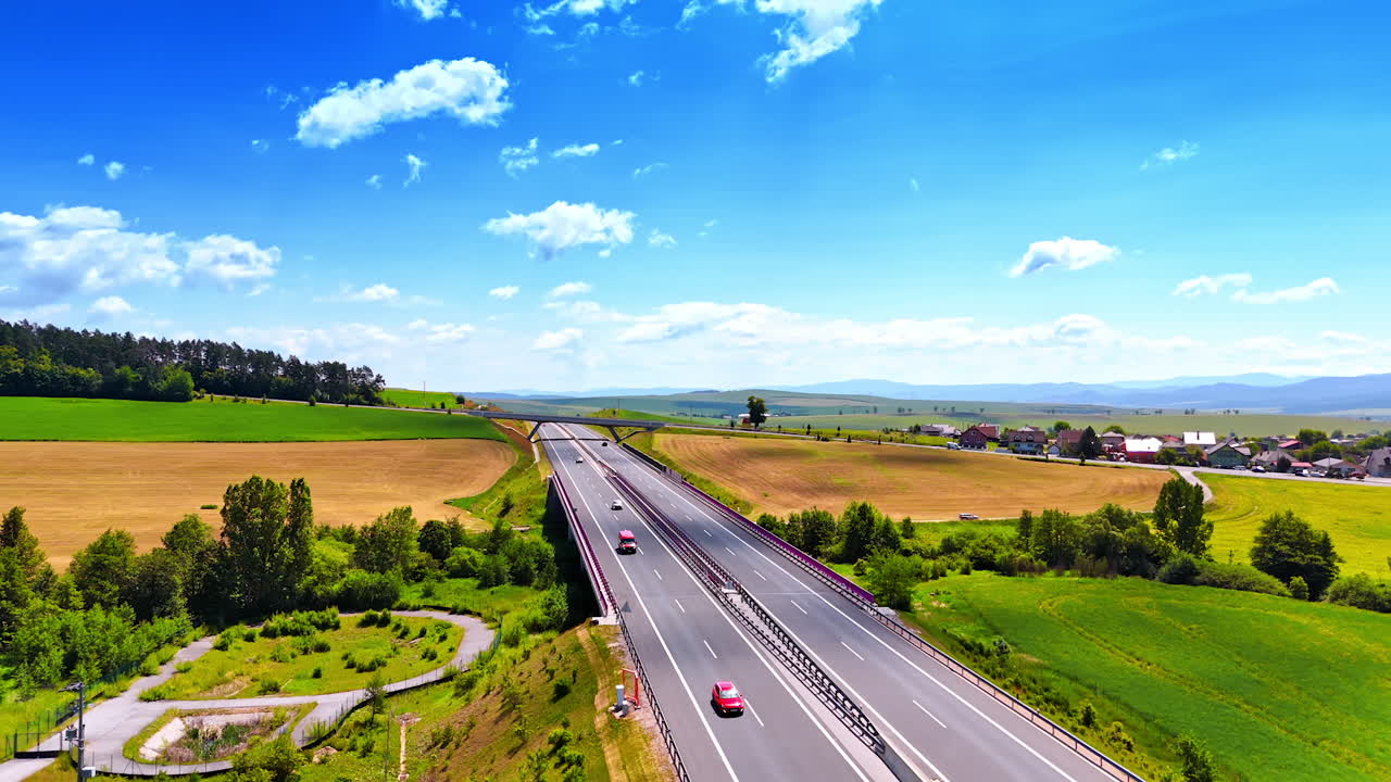 Footage above the freeway in the picturesque countryside. Aerial perspective on the spectacular sunny scenery in Slovakia crossed by the road