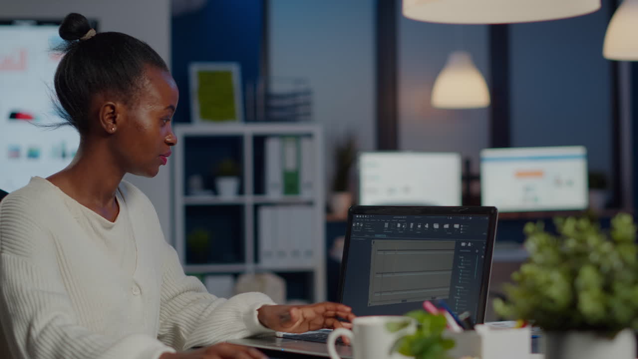 Black woman engineer designer looking at laptop analysing project