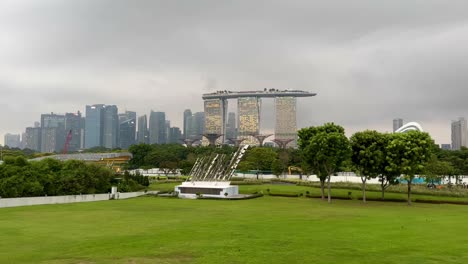 daytime footage from singapore harbor showcasing marina bay sands, gardens by the bay, avatar-like trees, and singapore's skyline on the left