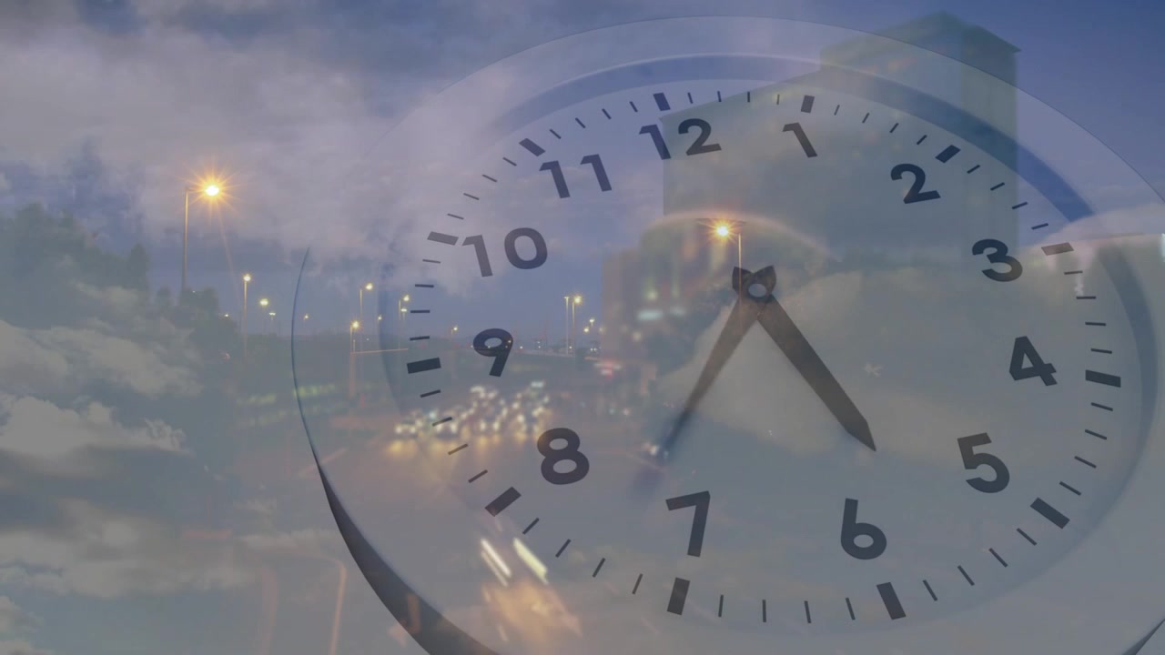 高速道路の上に時計の文字盤が現れ、針が回転し、交通が流れる中で時間の経過を示している。