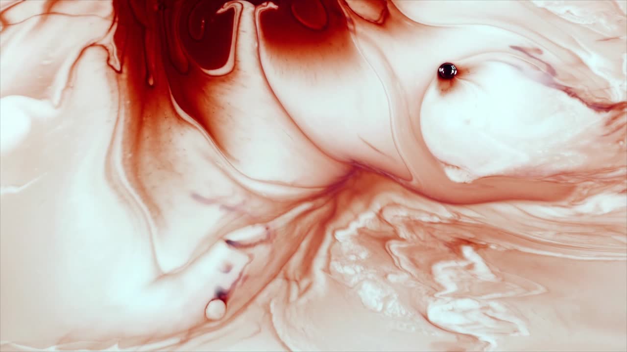 Inchiostro rosso astratto che si diffonde e vortica in un liquido bianco