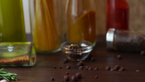 Closeup-of-spice-pepper-and-rosemary-herb-on-kitchen-table.-Spices-and-herbs