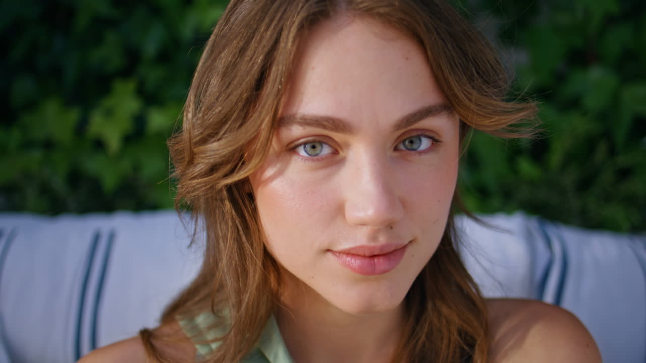 Attractive model looking camera sitting terrace surrounded greenery closeup