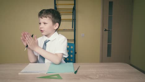 schoolboy does homework the wrench in his hands is a pen