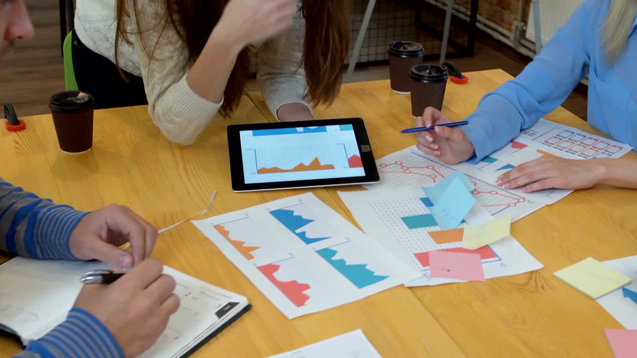 reunión de equipo de negocios tormenta de ideas compartiendo nuevas ideas equipo diverso involucrado en el trabajo en equipo en el espacio de oficina de ladrillo de moda steadicam disparado a través de la mesa de la sala de juntas espacio de trabajo compartido