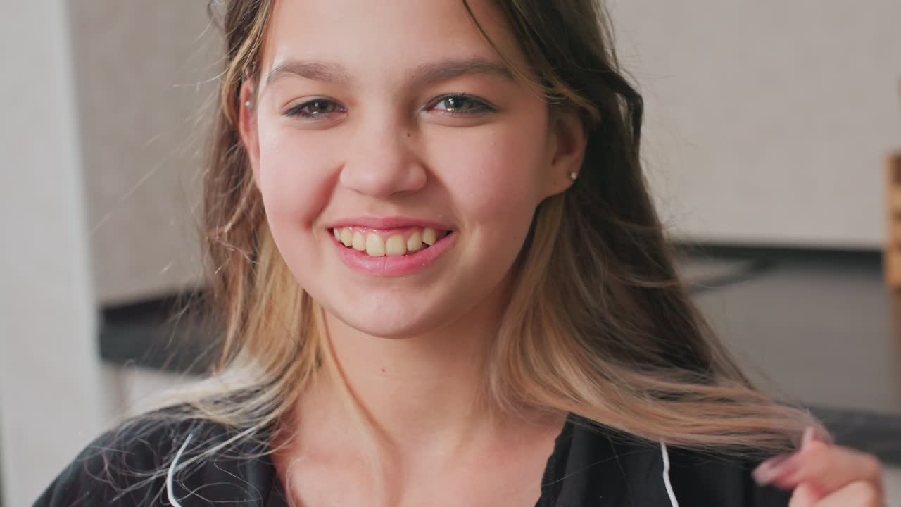 close up of happy young woman eating gummy candy and adjusting hair, smiling, indoor setting, casual mood, natural lighting, friendly expression, relaxed and joyful atmosphere