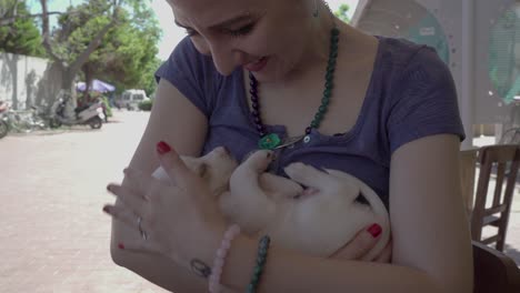 una hermosa mujer sosteniendo y acariciando a un cachorro marrón con amor