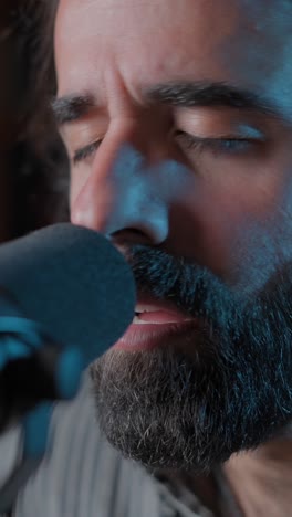 close-up of a bearded man singing into a microphone