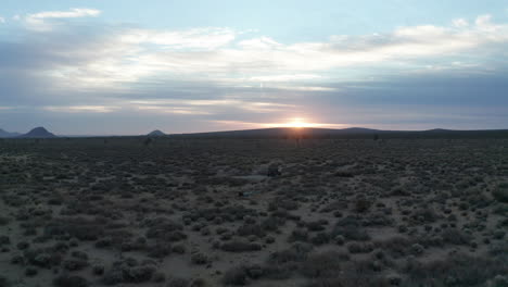 Jeep-parked-in-the-Mojave-Desert-to-watch-the-sunset-or-sunrise-in-this-vast-wilderness---aerial-fly-over