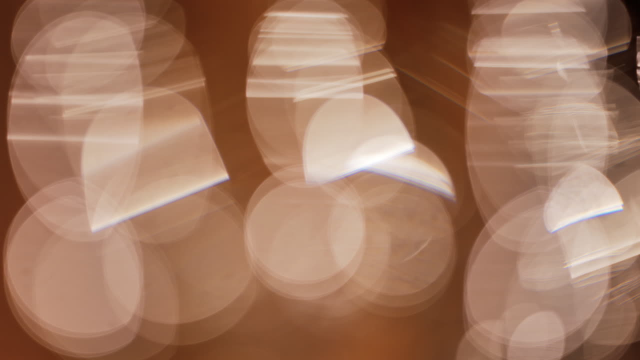 Abstract composition of light trails and overlapping bokeh in warm golden tones