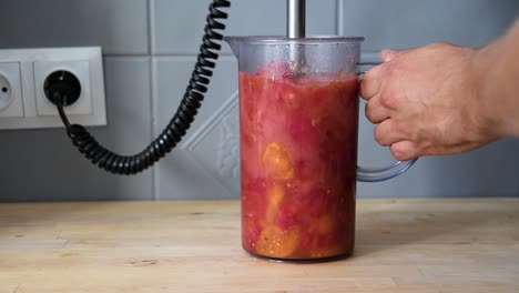 La-Mano-Del-Hombre-Hace-Salsa-De-Tomate,-Con-Licuadora-De-Inmersión