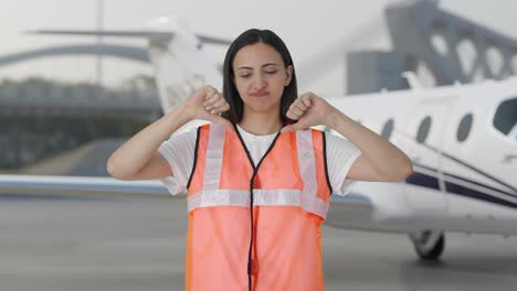 Enttäuschtes-Indisches-Bodenpersonalmädchen-Am-Flughafen-Zeigt-Daumen-Nach-Unten