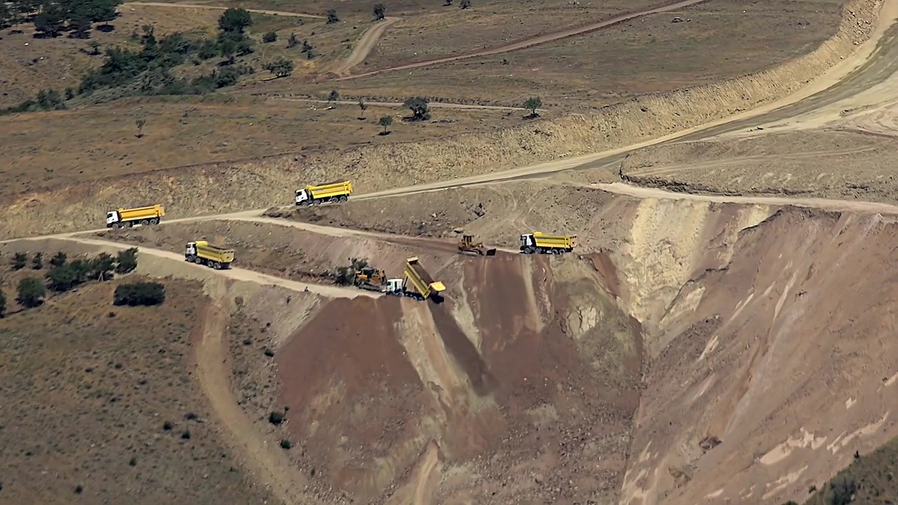 Aerial View of Dump Trucks Working at an Open Pit Mine