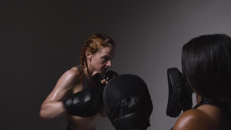 Studioaufnahme-Von-Zwei-Reifen-Frauen-In-Fitnesskleidung,-Die-Gemeinsam-Boxen-Und-Sparring-Trainieren