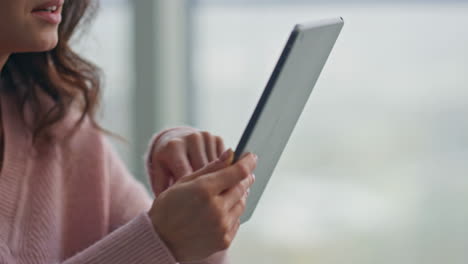 smiling housewife swiping tablet reading at kitchen closeup. lady holding pad