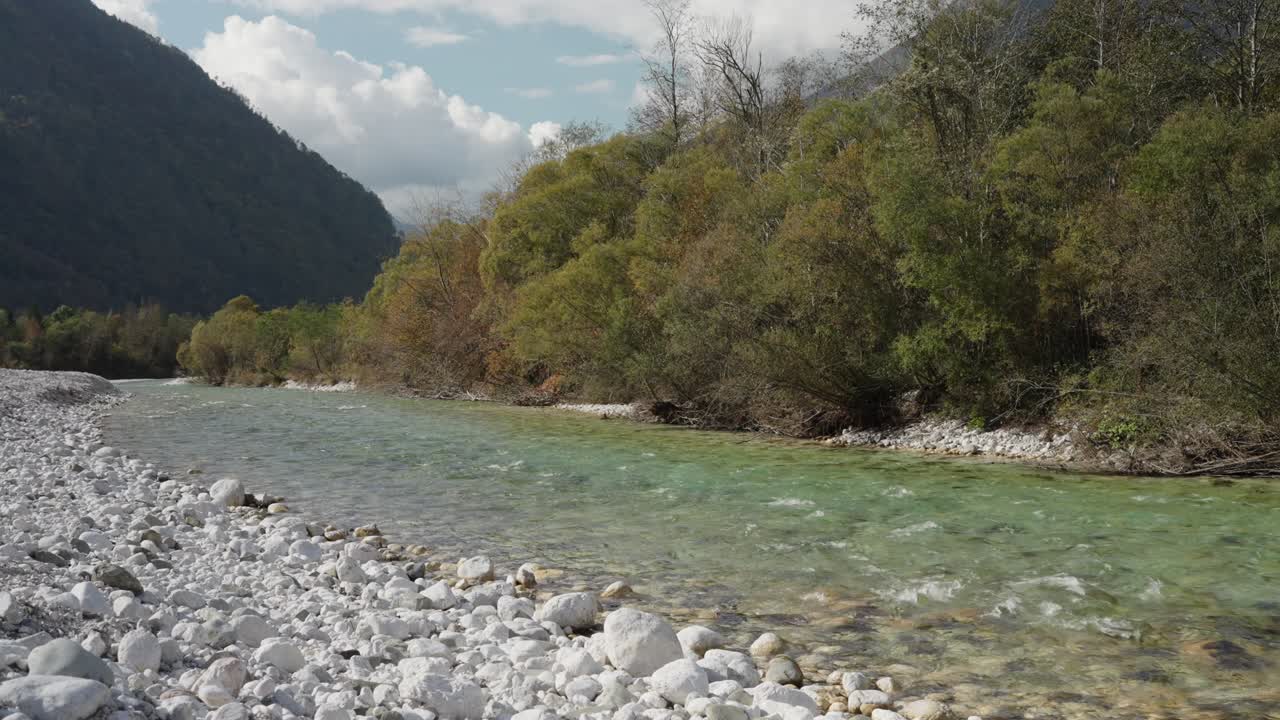 Tranquillo lungofiume con acqua limpida e sponda rocciosa a Bovec, Slovenia