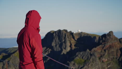 el hombre de la cazadora mira hacia las escarpadas montañas volcánicas de madeira portugal