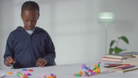 boy on asd spectrum at home playing with shape puzzle sitting at table