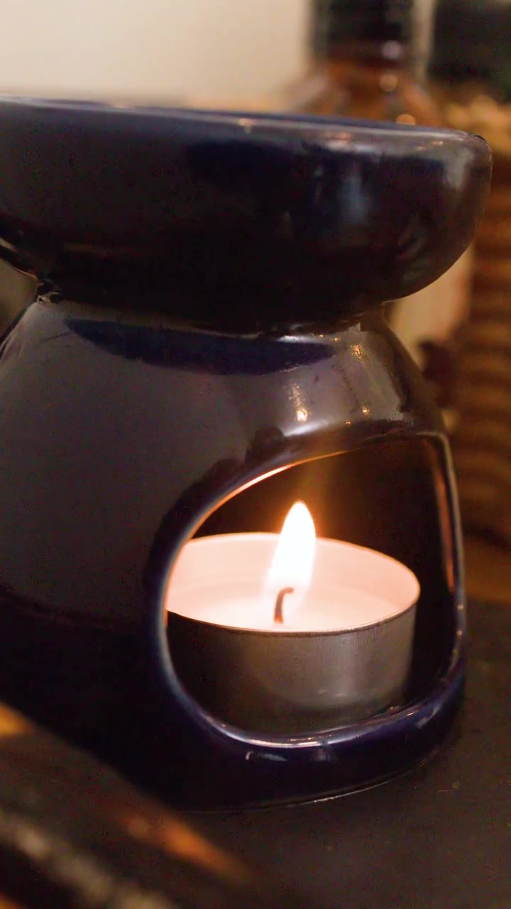 Gros plan sur une main utilisant un briquet pour allumer une bougie chauffe-plat.