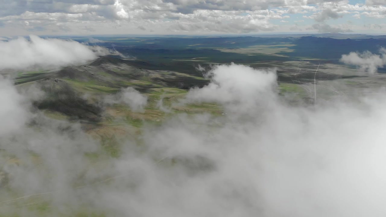 Aerial View of Rolling Green Hills and Clouds