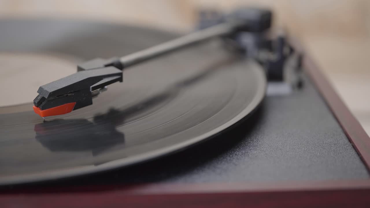 Mano che posiziona e solleva l'ago su un disco in vinile in riproduzione