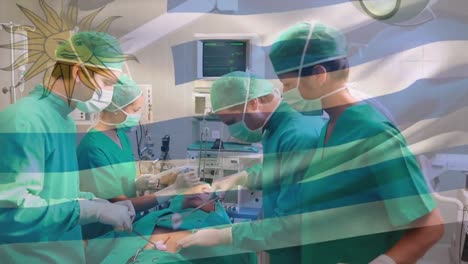 Animation-of-waving-uruguay-flag-over-team-of-diverse-surgeons-performing-surgery-at-hospital
