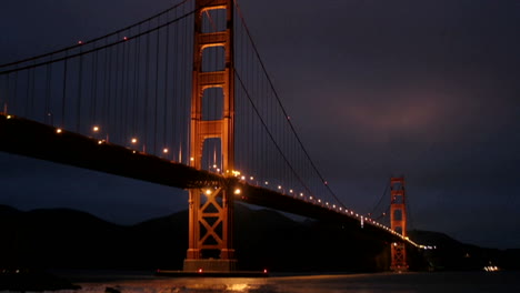 el puente golden gate de san francisco está iluminado en un cielo oscuro