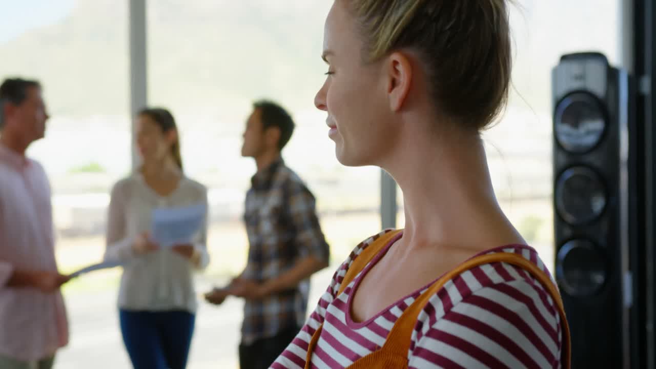 joven ejecutiva de negocios caucásica feliz de pie en una oficina moderna 4k