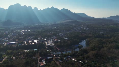 una vista impresionante de sangklaburi y su paisaje rural revela altas montañas y llamaradas solares que iluminan el valle.