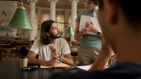 young student studying with tutor in library