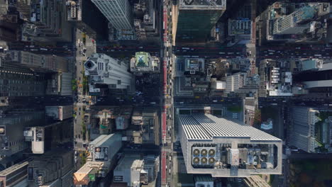 Aerial-birds-eye-overhead-top-down-view-of-city.-Fly-over-high-rise-downtown-buildings.-Traffic-in-streets-between.-Manhattan,-New-York-City,-USA