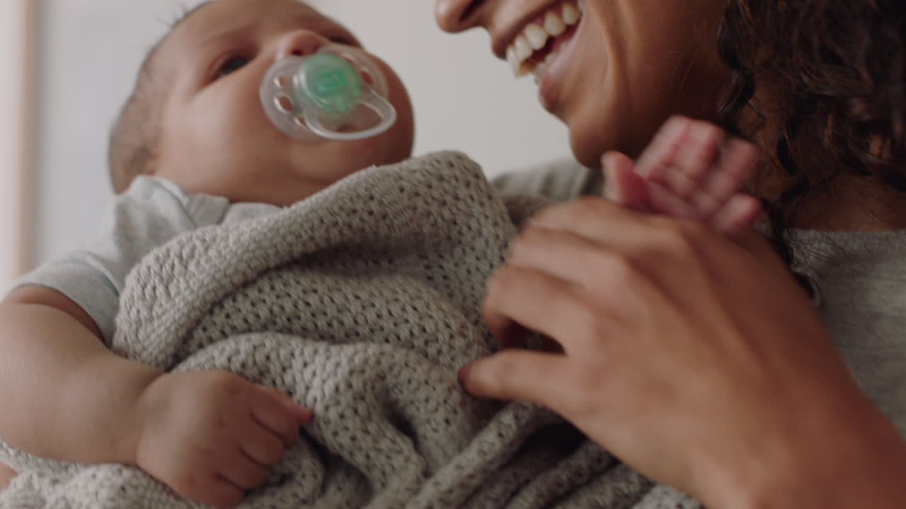 mother holding baby at home calming tired newborn gently soothing restless infant sucking on pacifier loving mom enjoying motherhood