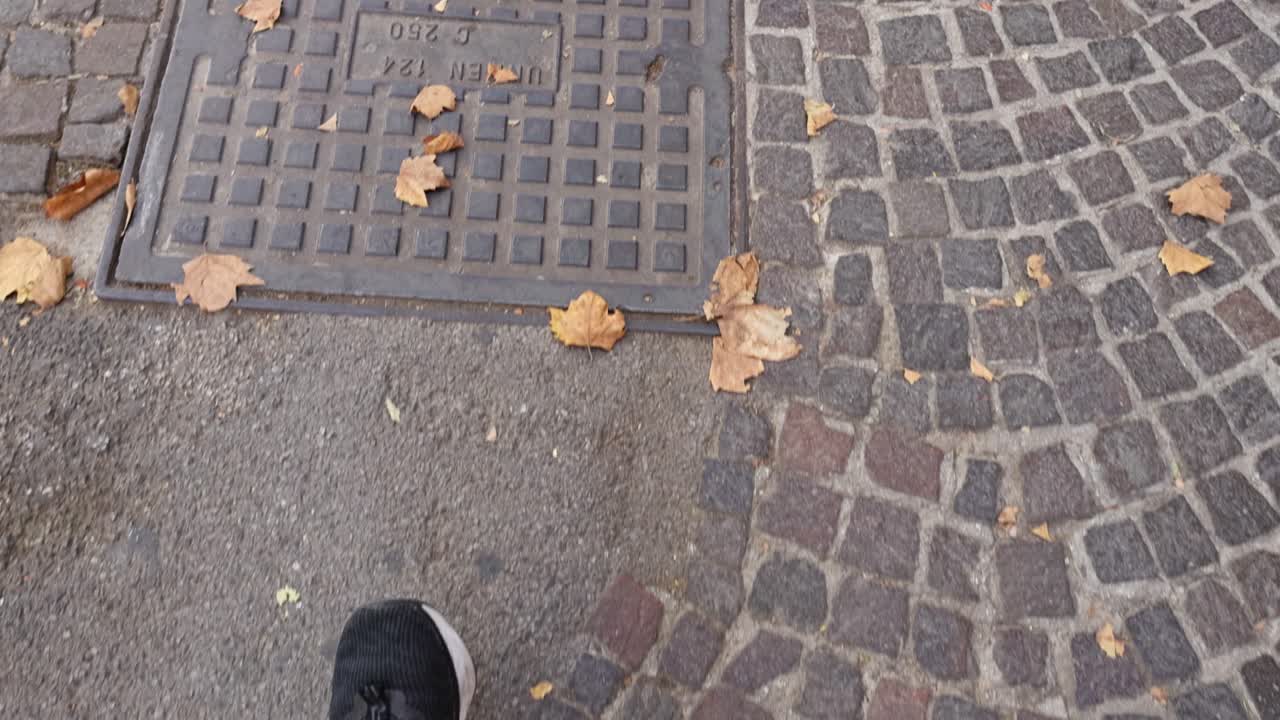 Footsteps on cobblestone streets with fallen leaves